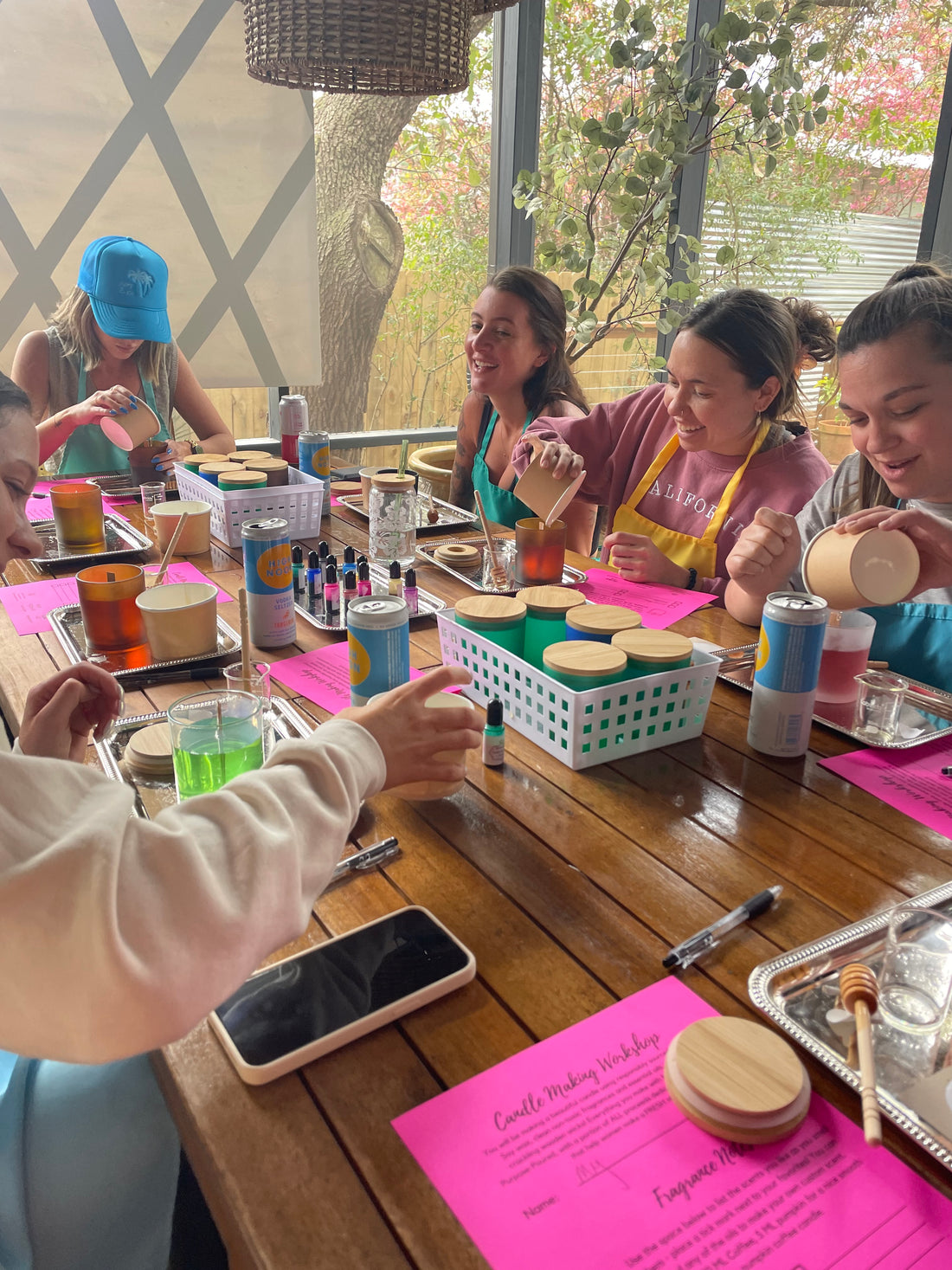 Group of bachelorettes smiling and laughing while making candles in their 30a area vacation rental.