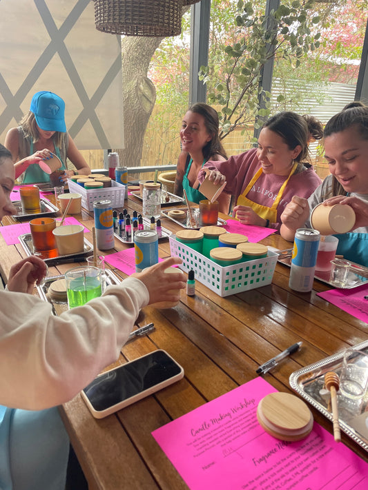 Group of bachelorettes smiling and laughing while making candles in their 30a area vacation rental. 